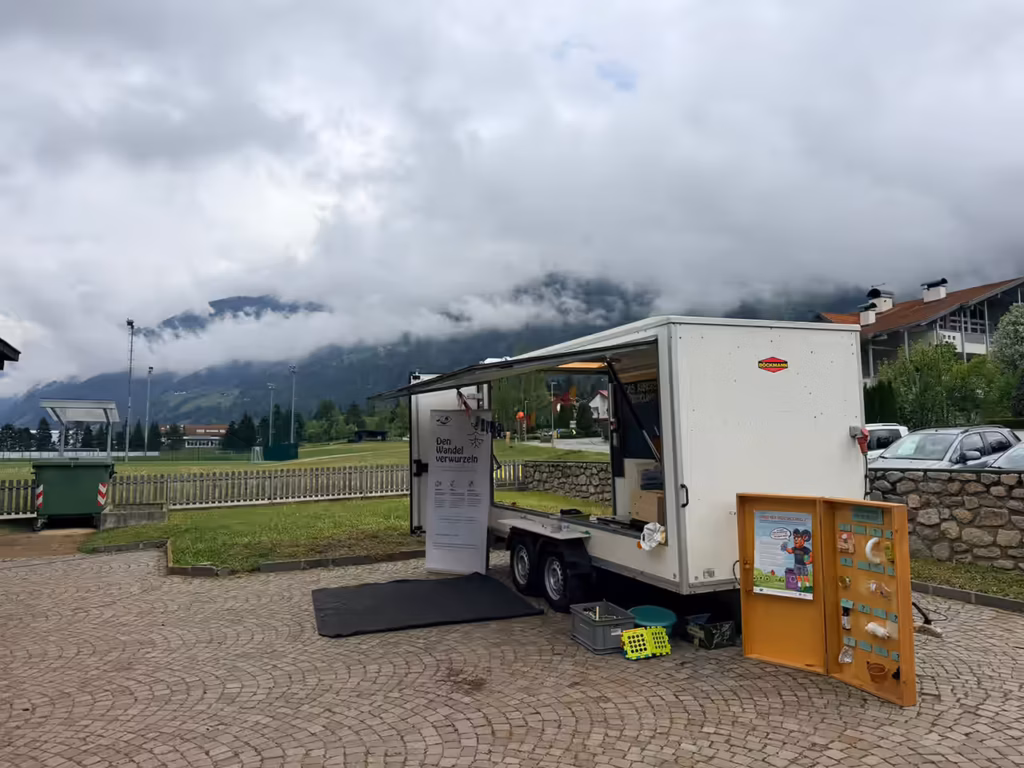Italientour - Kindergarten Gais - Recycling-Mobil mit vernebelten Bergen im Hintergrund