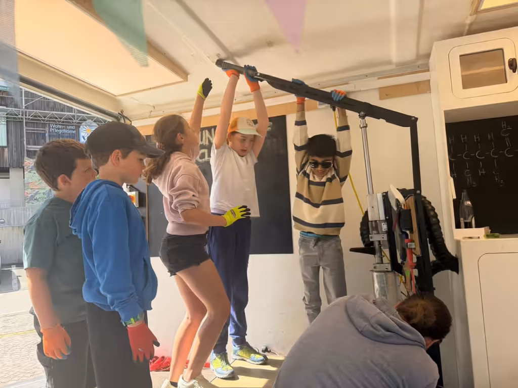 Italientour - Schule Olang - Kinder pressen sich ein Produkt aus Müll mit der Spritzgussmaschine